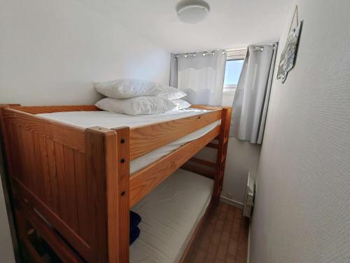 - une chambre avec des lits superposés à côté d'un réfrigérateur dans l'établissement Studio cabine 20m de la plage avec parking - Cap d'Agde - FR-1-607-71, au Cap d'Agde