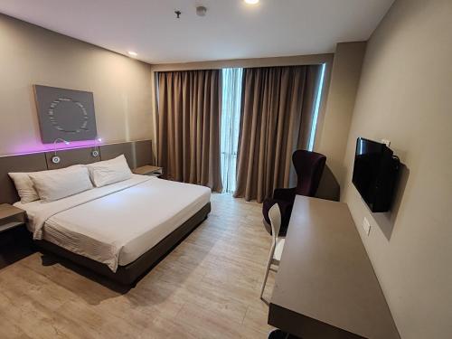 八打灵再也QQQ hotel type room Empire Damansara的一间配有床和电视的酒店房间