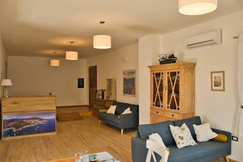 a living room with a blue couch and a table at Dommu Livia in Lotzorai