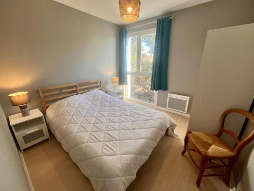 une chambre avec un lit, une fenêtre et une chaise dans l'établissement Appartement 4 pièces avec parking, proche plage à Cavalaire - FR-1-226B-182, à Cavalaire-sur-Mer