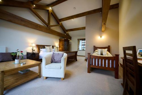 a bedroom with a bed and a chair and a table at Green Grove Country House in Malham