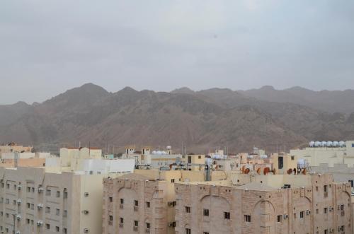 a group of buildings with mountains in the background at Al Rayhan Suites الريحان للأجنحة المفروشة in Al Madinah