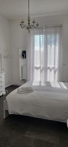 a bedroom with a large white bed with a window at La Casa dei Sogni in Brugherio