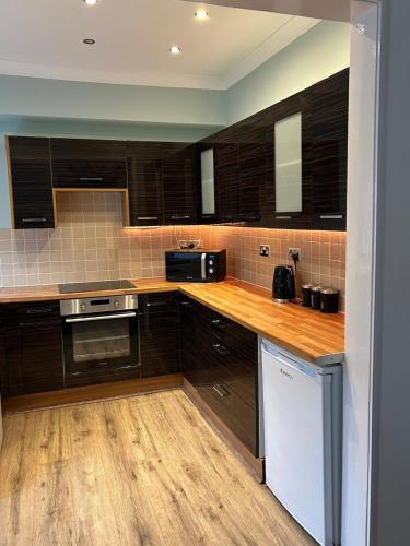 a kitchen with brown cabinets and a counter top at Shoreside - Beach Family Home in Exmouth