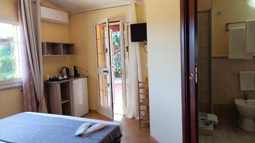 a bedroom with a bed and a door to a bathroom at Li Muntigeddi in San Teodoro