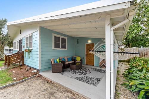 a blue house with a porch and a patio at Sandy Feet Getaway Spacious Coastal Retreat 3 MIn Walk to Coast in Gulfport