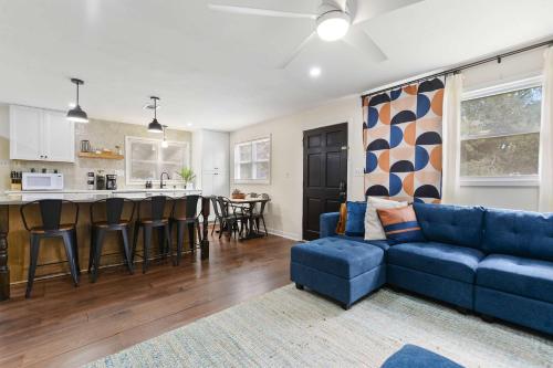 a living room with a blue couch and a kitchen at Sandy Feet Getaway Spacious Coastal Retreat 3 MIn Walk to Coast in Gulfport