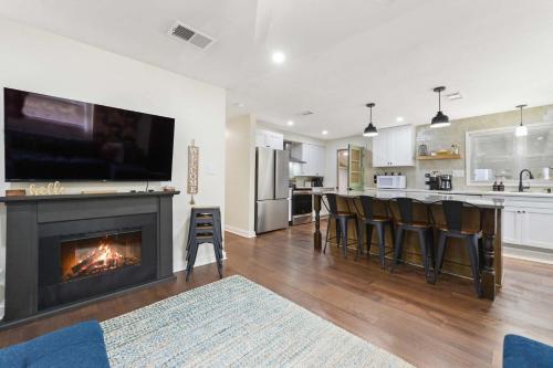 a living room with a fireplace with a tv above it at Sandy Feet Getaway Spacious Coastal Retreat 3 MIn Walk to Coast in Gulfport