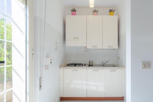 a kitchen with white cabinets and a sink at Villa Amore - San Lorenzo in San Lorenzo