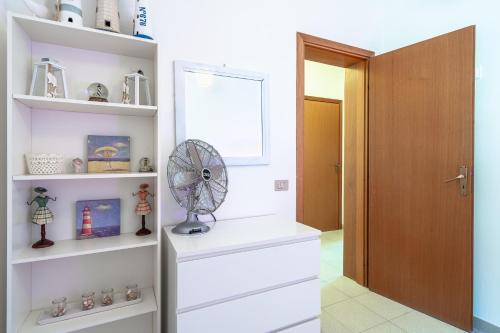 a room with white shelves and a fan at Villa Amore - San Lorenzo in San Lorenzo