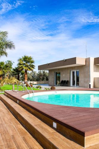 a swimming pool in front of a house at Villa Margares in Valenzano