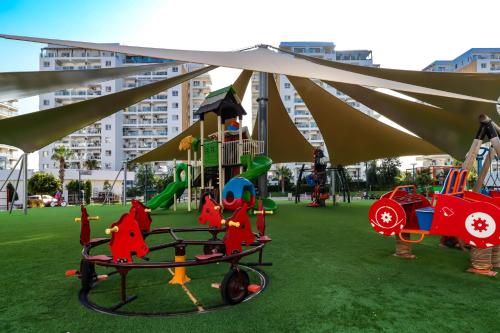 a playground in a park with a swing set at Ground Garden & Pool View Spacious Apartment at Caesar Resort & SPA in Mağusa