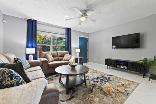 a living room with a couch and a tv at Ocean Breeze A Relaxing Coastal Getaway Near Top Attractions in Gulfport
