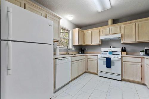 a kitchen with white appliances and wooden cabinets at Ocean Breeze A Relaxing Coastal Getaway Near Top Attractions in Gulfport