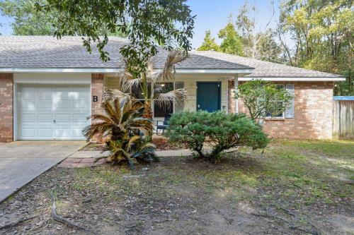 a house with a palm tree in front of it at Sunset Getaway Spacious Retreat Near Beaches & Local Attractions in Gulfport