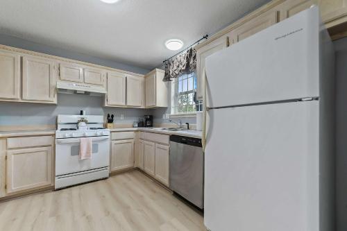 a kitchen with white appliances and a white refrigerator at Sunset Getaway Spacious Retreat Near Beaches & Local Attractions in Gulfport