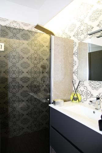 a bathroom with a sink and a shower with a mirror at Villa Margares in Valenzano