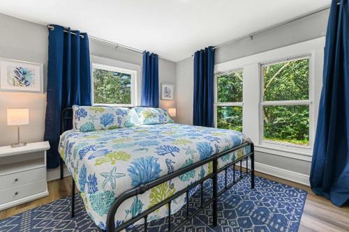 ガルフポートにあるCoastal Casa -Charming 3 Bedroom Houseのベッドルーム1室(青いカーテン、青いベッドカバー付)