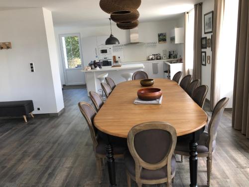 une cuisine et une salle à manger avec une table et des chaises en bois dans l'établissement Domaine de mandrin, à Madranges