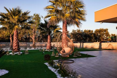 a garden with palm trees and a swing at Villa Margares in Valenzano