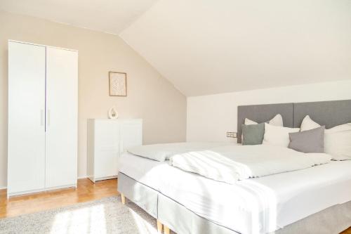 a white bedroom with a large white bed at APARTMENT an den Weinbergen in Iphofen