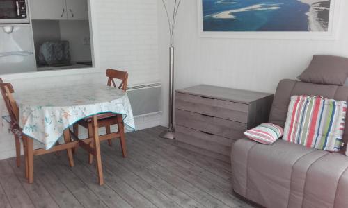 un salon avec une table et un canapé dans l'établissement Arcachon Plage Pereire, à Arcachon