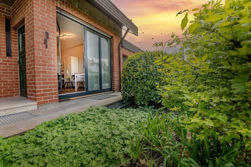 a brick house with a window and a garden at APARTMENT an den Weinbergen in Iphofen