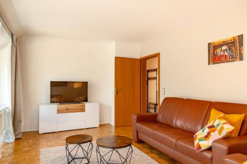 a living room with a couch and a tv at APARTMENT an den Weinbergen in Iphofen