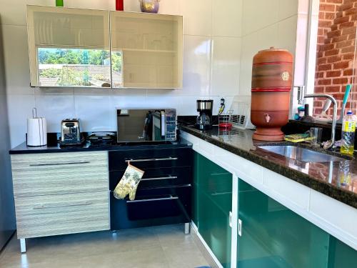 ミゲウ・ペレイラにあるCasa espaçosa prox Centro Mini academia e 1 king sizeのキッチン(緑のキャビネット、カウンタートップ付)