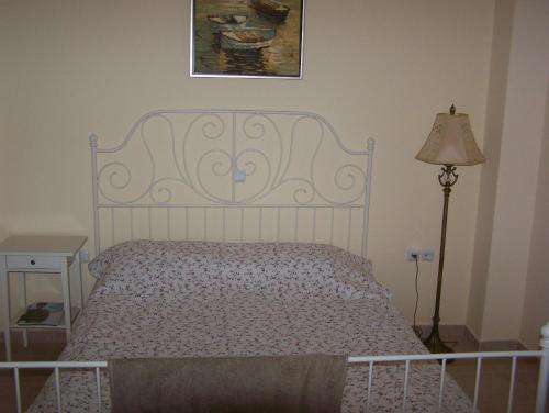 a bed in a bedroom with a picture on the wall at Eirini Apartment in Nea Kalikratia