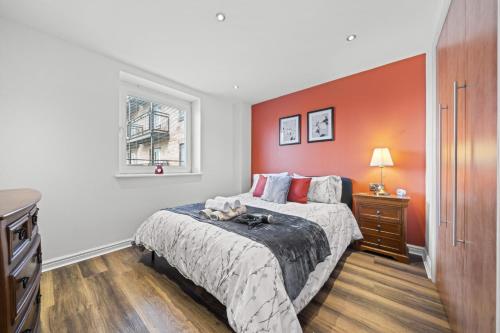 a bedroom with a bed with an orange wall at Slateford 2 Bedroom Apartment - Edinburgh in Edinburgh