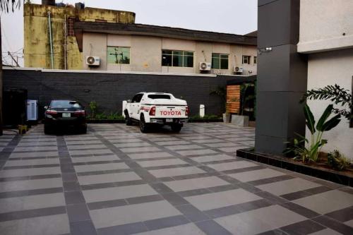 a white truck parked in front of a building at Hotel Padelia International Airport Road Lagos in Ejigbo
