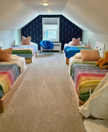 a boys room with three beds and a chair at Lucky 8 Camp Cozy Coastal Retreat with Hidey Hole & Family Charm in Waterford