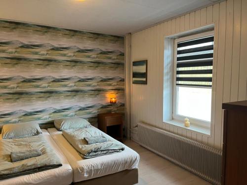 a bedroom with two beds and a painting on the wall at Vakantiehuis 't Geultje in Schin op Geul