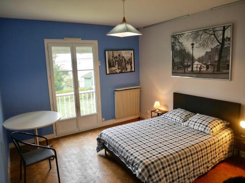 une chambre avec un lit, une table et une fenêtre dans l'établissement La maison des retrouvailles aux portes de Tours, à Saint-Avertin