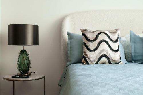 a bed with a pillow and a lamp on a table at Cofresi Hills Residence in Gurapito