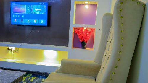 a living room with a chair and a tv at SpringStone executive apartment in Ongata Rongai 