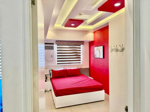 a red room with a bed with a red couch at Avida Riala Tower 2, IT Park, New Fully Furnished in Cebu City