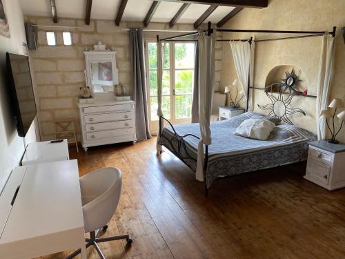 - une chambre avec un lit à baldaquin et une commode dans l'établissement Mas de Sophie, à Châteaurenard