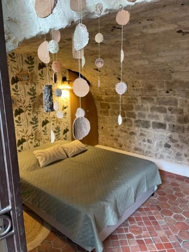 a bedroom with a bed in a brick wall at Sous la Glycine in Giverny