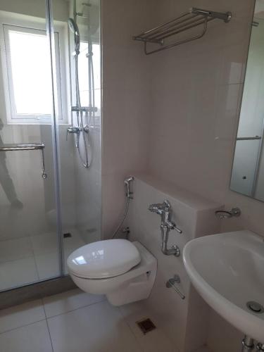 a white bathroom with a toilet and a sink at Urban living at Fairway in Battaramulla
