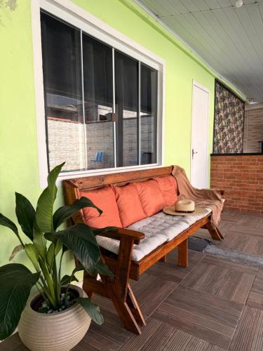 a porch with a bench in front of a window at Casa com piscina em Florianópolis in Florianópolis