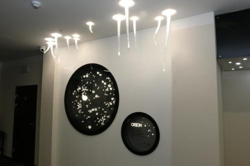 two black clocks on a wall with lights at Apartment Hotel Orion in Abertamy