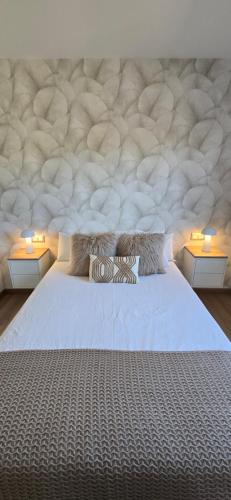 a bedroom with a large white bed with two lamps at Casa acogedora Mar de Albariño con Piscina in Cambados