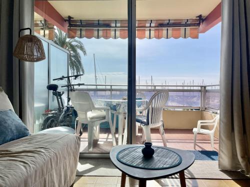 un salon avec une table et des chaises sur un balcon dans l'établissement Studio face port et mer, à Menton