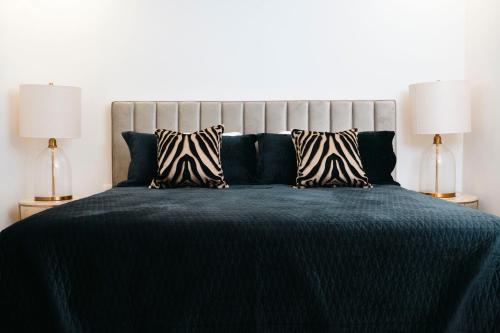 a bedroom with a bed with a blue comforter and two lamps at Cofresi Hills Residence in Gurapito