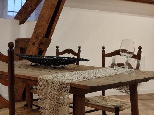 une table en bois avec deux verres à vin dessus dans l'établissement D'am Chic Nomade Campagne en ville, à Périgueux