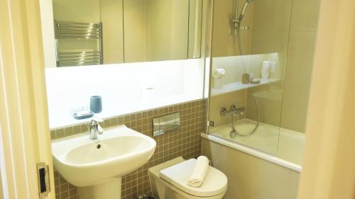 a bathroom with a sink and a toilet and a shower at Spacious & Elegant Apartments in Southbank near London Eye in London