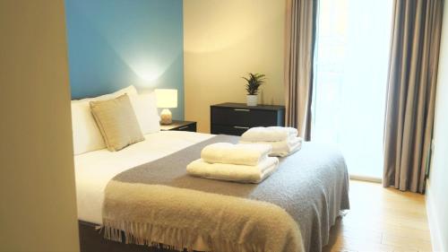 a bedroom with a bed with towels on it at Spacious & Elegant Apartments in Southbank near London Eye in London