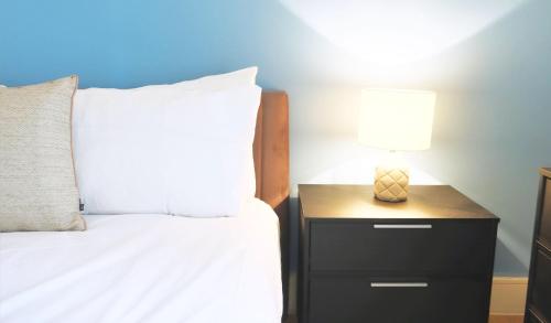 a bedroom with a bed and a nightstand with a lamp at Spacious & Elegant Apartments in Southbank near London Eye in London
